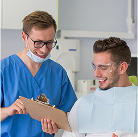 Dentist showing a patient information on a clipboard